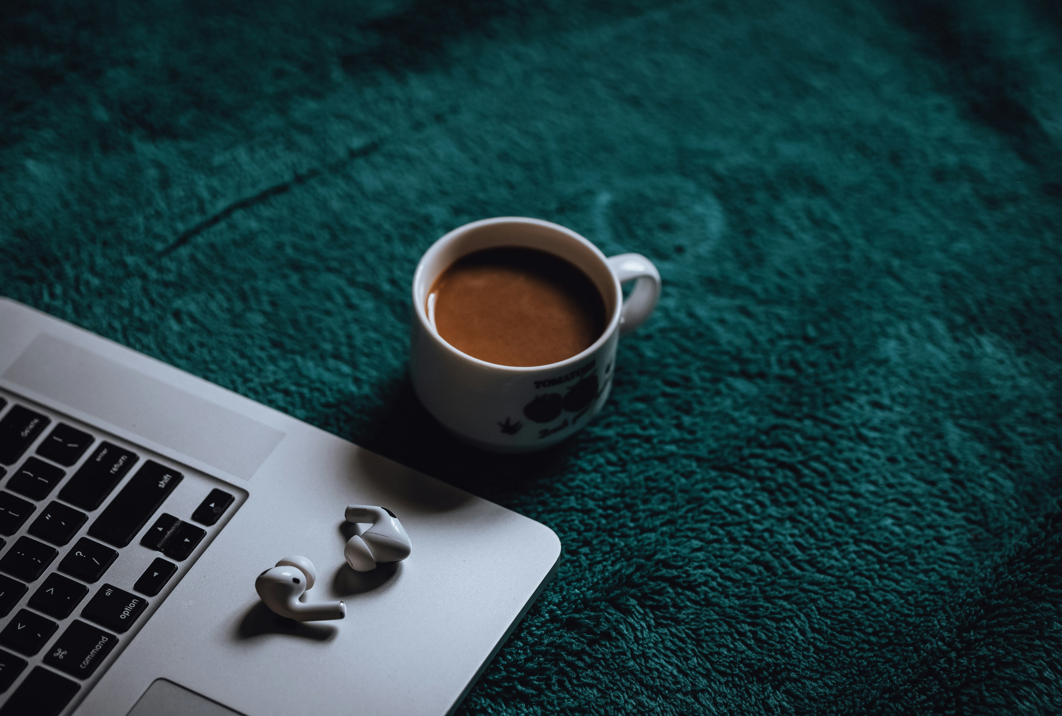 white ceramic mug on white and black laptop computer